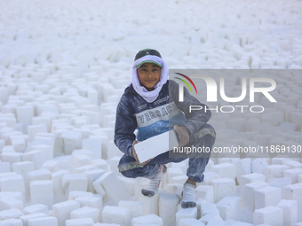 Labourers work at the ''White Mountain'' limestone extraction quarry site near Minya, Egypt, on December 14, 2024. Covered in fine white dus...