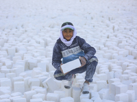 Labourers work at the ''White Mountain'' limestone extraction quarry site near Minya, Egypt, on December 14, 2024. Covered in fine white dus...