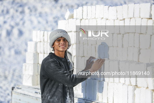 Labourers work at the ''White Mountain'' limestone extraction quarry site near Minya, Egypt, on December 14, 2024. Covered in fine white dus...