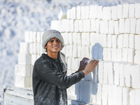 Labourers work at the ''White Mountain'' limestone extraction quarry site near Minya, Egypt, on December 14, 2024. Covered in fine white dus...