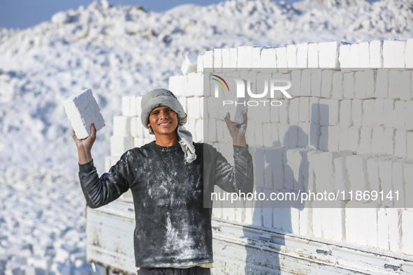 Labourers work at the ''White Mountain'' limestone extraction quarry site near Minya, Egypt, on December 14, 2024. Covered in fine white dus...