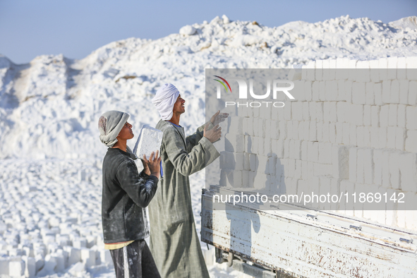 Labourers work at the ''White Mountain'' limestone extraction quarry site near Minya, Egypt, on December 14, 2024. Covered in fine white dus...