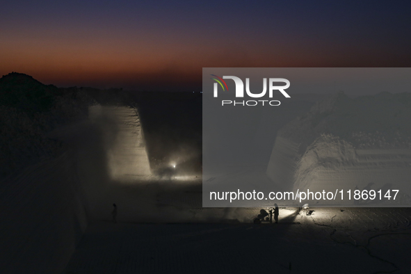 Labourers work at the ''White Mountain'' limestone extraction quarry site near Minya, Egypt, on December 14, 2024. Covered in fine white dus...