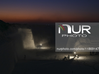 Labourers work at the ''White Mountain'' limestone extraction quarry site near Minya, Egypt, on December 14, 2024. Covered in fine white dus...