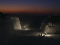 Labourers work at the ''White Mountain'' limestone extraction quarry site near Minya, Egypt, on December 14, 2024. Covered in fine white dus...