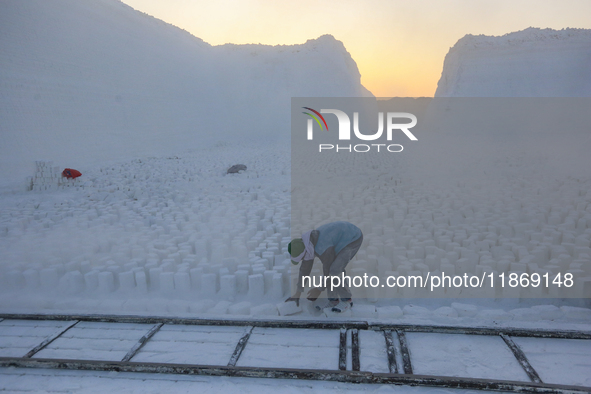 Labourers work at the ''White Mountain'' limestone extraction quarry site near Minya, Egypt, on December 14, 2024. Covered in fine white dus...