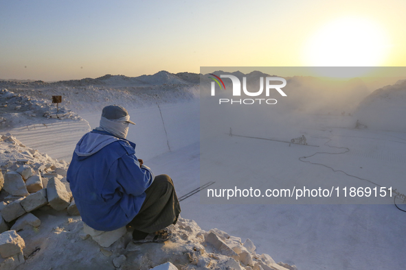 Labourers work at the ''White Mountain'' limestone extraction quarry site near Minya, Egypt, on December 14, 2024. Covered in fine white dus...