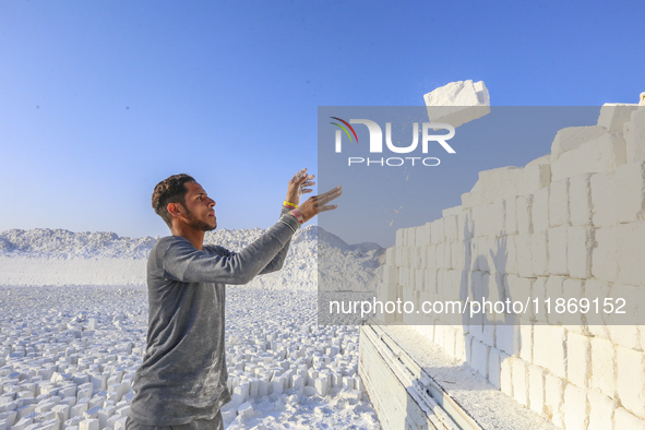 Labourers work at the ''White Mountain'' limestone extraction quarry site near Minya, Egypt, on December 14, 2024. Covered in fine white dus...