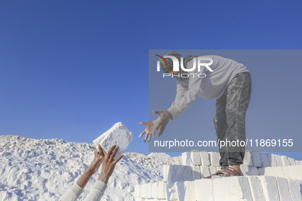 Labourers work at the ''White Mountain'' limestone extraction quarry site near Minya, Egypt, on December 14, 2024. Covered in fine white dus...