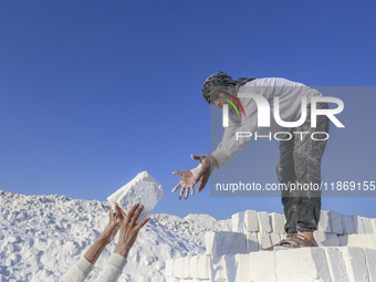 Labourers work at the ''White Mountain'' limestone extraction quarry site near Minya, Egypt, on December 14, 2024. Covered in fine white dus...