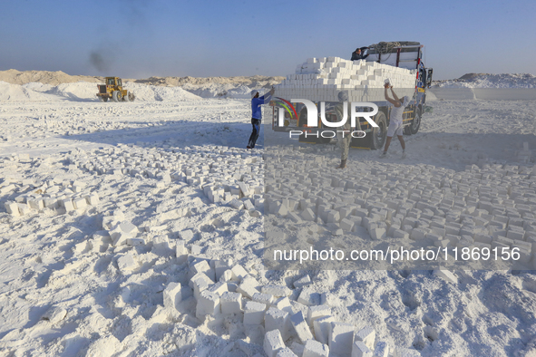 Labourers work at the ''White Mountain'' limestone extraction quarry site near Minya, Egypt, on December 14, 2024. Covered in fine white dus...