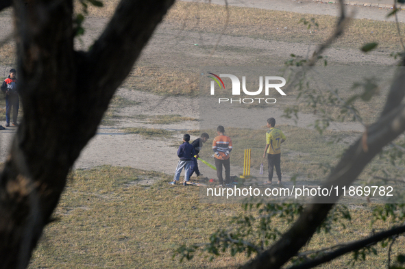 Indian children play cricket at a ground in Siliguri, India, on December 15, 2024. 