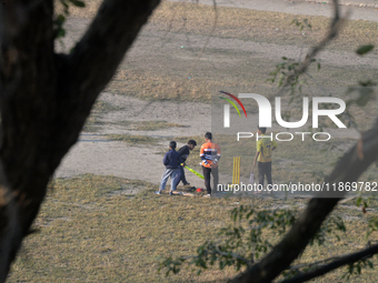 Indian children play cricket at a ground in Siliguri, India, on December 15, 2024. (