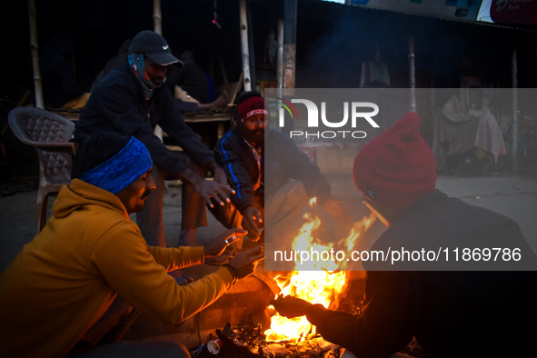 People warm themselves by a fire on a cold winter morning in Kolkata, India, on December 15, 2024. 