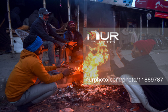 People warm themselves by a fire on a cold winter morning in Kolkata, India, on December 15, 2024. 