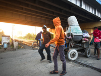 Laborers pull a construction machine to cross a railway track in Kolkata, India, on December 15, 2024. (