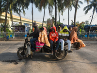 People travel on a motor cart on an early winter morning in Kolkata, India, on December 15, 2024. (