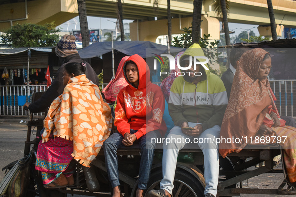 People travel on a motor cart on an early winter morning in Kolkata, India, on December 15, 2024. 