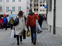 In Nuremberg, Bavaria, Germany, on December 14, 2024, a couple walks along a cobblestone street. The man, dressed in a bright orange jacket,...