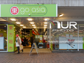 The 'Go Asia' supermarket in Augsburg, Bavaria, Germany, on December 14, 2024, stands out with its bright green signage and glass-panel entr...