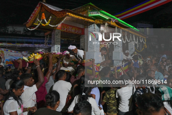 People attend a procession before the start of the Adams Peak (Sri Pada) season in Ratnapura, Sri Lanka, on December 13, 2024. The site is k...