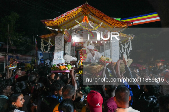 People attend a procession before the start of the Adams Peak (Sri Pada) season in Ratnapura, Sri Lanka, on December 13, 2024. The site is k...