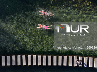 Winter swimming enthusiasts swim in the natural waters of Heilong Cave in Handan, China, on December 15, 2024. (