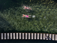 Winter swimming enthusiasts swim in the natural waters of Heilong Cave in Handan, China, on December 15, 2024. (