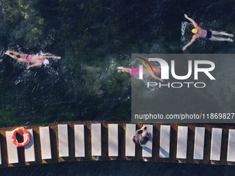 Winter swimming enthusiasts swim in the natural waters of Heilong Cave in Handan, China, on December 15, 2024. (