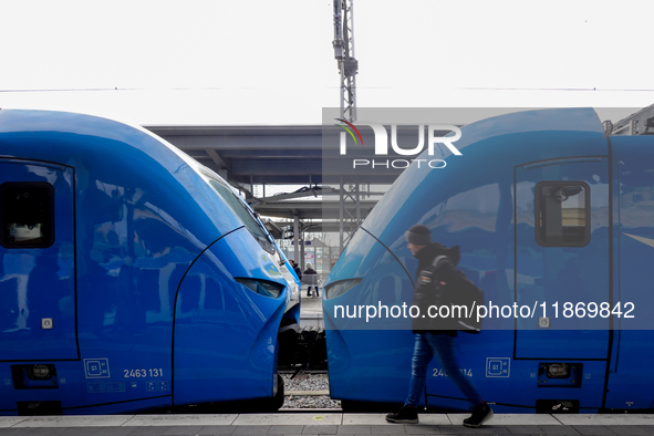 A passenger stands near an Arverio train at Augsburg Central Station in Bavaria, Germany, on December 14, 2024. 