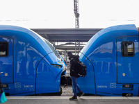 A passenger stands near an Arverio train at Augsburg Central Station in Bavaria, Germany, on December 14, 2024. (