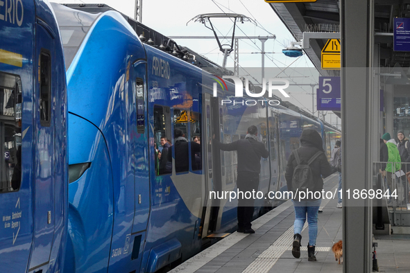 At Platform 5 of Augsburg Central Station in Bavaria, Germany, on December 14, 2024, a train attendant ensures smooth boarding for passenger...