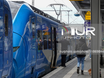 At Platform 5 of Augsburg Central Station in Bavaria, Germany, on December 14, 2024, a train attendant ensures smooth boarding for passenger...