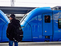 A passenger with a backpack waits on the platform as an Arverio regional train is stationed at Augsburg Central Station in Bavaria, Germany,...