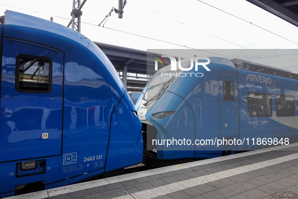 Two Arverio regional trains stand coupled at Augsburg Central Station in Bavaria, Germany, on December 14, 2024. The bright blue trains refl...