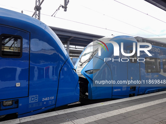 Two Arverio regional trains stand coupled at Augsburg Central Station in Bavaria, Germany, on December 14, 2024. The bright blue trains refl...