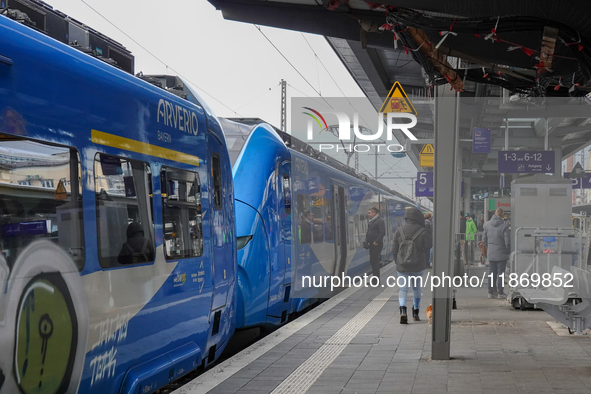 At Platform 5 of Augsburg Central Station in Bavaria, Germany, on December 14, 2024, a train attendant ensures smooth boarding for passenger...