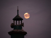 The final full moon, or cold moon, rises behind the minaret of a mosque in Srinagar, Kashmir, India, on December 14, 2024. In India, reports...