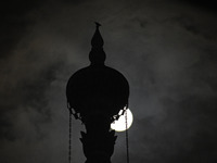 The final full moon, or cold moon, rises behind the minaret of a mosque in Srinagar, Kashmir, India, on December 14, 2024. In India, reports...