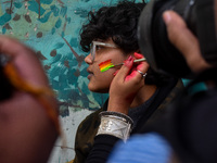 A participant paints pride flags on the cheeks of others during the annual pride walk in Kolkata, India, on December 15, 2024. (