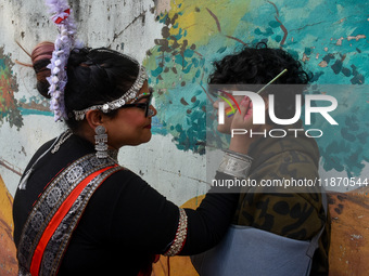 A participant paints pride flags on the cheeks of others during the annual pride walk in Kolkata, India, on December 15, 2024. (