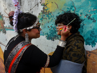 A participant paints pride flags on the cheeks of others during the annual pride walk in Kolkata, India, on December 15, 2024. (