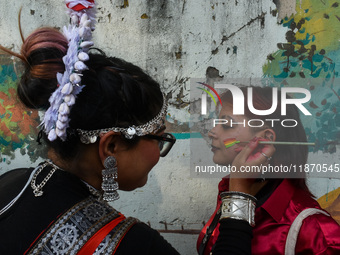 A participant paints pride flags on the cheeks of others during the annual pride walk in Kolkata, India, on December 15, 2024. (