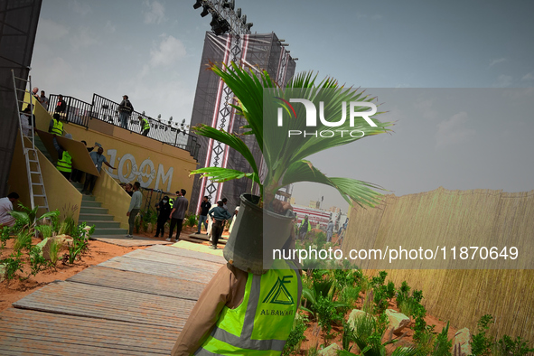 A migrant worker carries a potted Fiji Fan Palm at a construction site near Riyadh, Saudi Arabia on 03 March, 2024. 