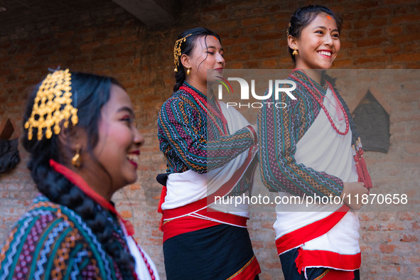 A girl in traditional Newari attire ties her friend's hair. 