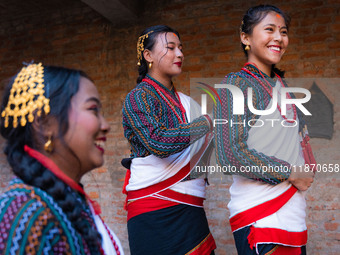 A girl in traditional Newari attire ties her friend's hair. (