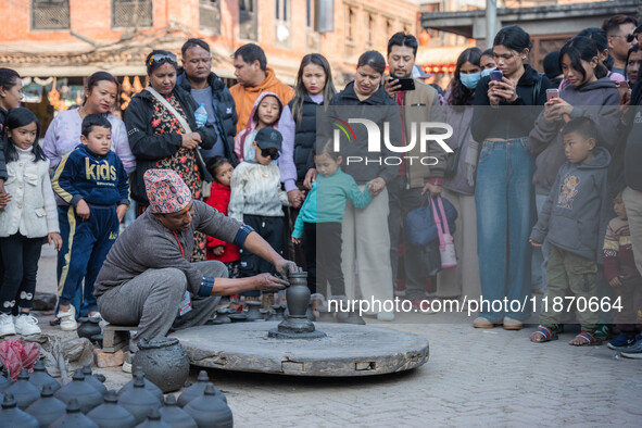 The crowd watches a man demonstrate pottery-making at Bhaktapur Durbar Square during the Bhaktapur Mahotsav (Bhaktapur Street Festival) on S...