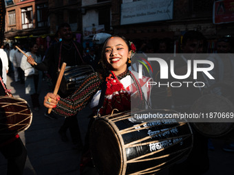 A young woman dressed in traditional Newari attire plays the dhime drum in Bhaktapur, Nepal, on Sunday. (