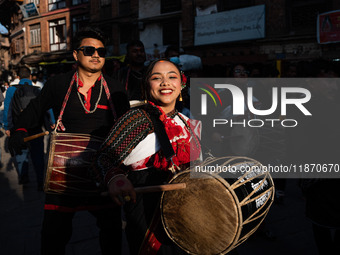 A young woman dressed in traditional Newari attire plays the dhime drum in Bhaktapur, Nepal, on Sunday. (