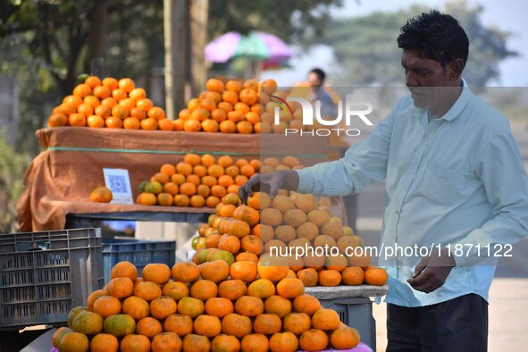 A vendor arranges oranges at his roadside shop for sale near Sonapur in Kamrup District of Assam, India, on December 15, 2024. 